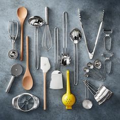 a collection of kitchen utensils and spoons arranged on a table with gray background