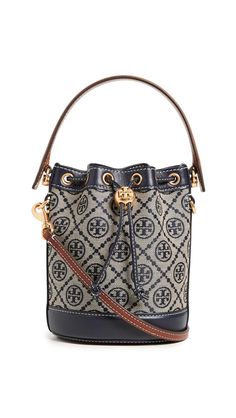 PRICES MAY VARY. Fabric: Jacquard Monogram pattern, Leather trim, Gold-toned hardware Length: 6in / 15cm, Height: 7in / 18cm, Handle drop: 3.5in / 9cm, Strap drop: 21.25in / 54cm, Depth: 4.75in / 12cm Drawstring closure Optional, adjustable shoulder strap A scaled-down Tory Burch bucket bag, detailed with a rendition of the label's monogram for a polished and eye-catching look. Two shades of leather trim lend a subtle update to the silhouette. Tory Burch Bucket Bag, T Monogram, Mini Bucket Bag, Mini Bucket, Mini Bucket Bags, Monogram Pattern, Tory Burch Bag, Blue Bags, Leather Trim