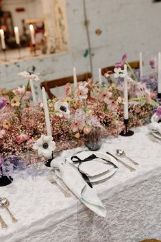 the table is set with flowers and candles