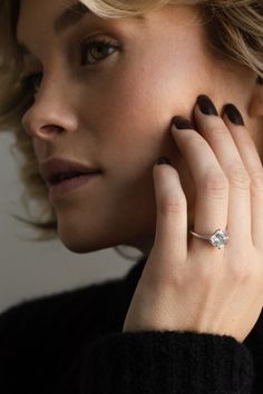 a woman wearing a diamond ring on her finger