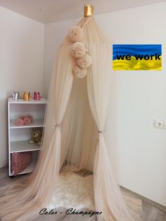 a white canopy bed with a teddy bear on top and we work sign in the background