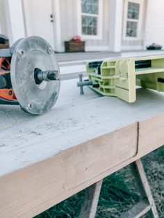 a machine that is sitting on top of a wooden table in front of a house