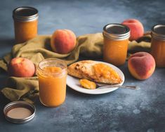 peach jam and sliced peaches on a plate next to two jars of peach preserves