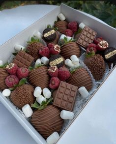 a box filled with chocolate covered strawberries and marshmallows