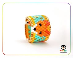 an orange, yellow and blue beaded bracelet on a white background with a penguin