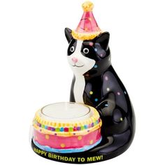 a black and white cat figurine with a birthday hat on it's head