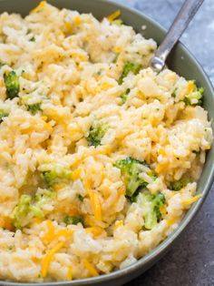 a bowl filled with rice and broccoli on top of a table