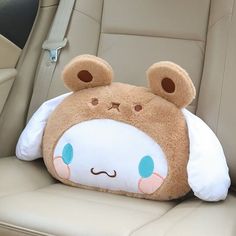 a teddy bear pillow sitting in the back seat of a car