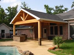 a covered patio next to a pool with a grill and table in the back yard