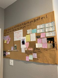 a bulletin board covered in post it notes and magnets on the side of a wall