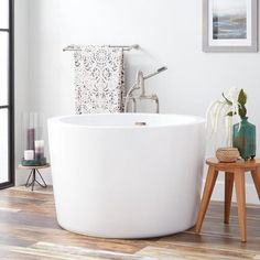 a white bath tub sitting on top of a wooden floor