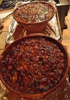 two pies sitting on top of foil covered pans