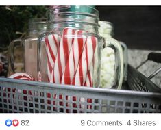 some candy canes are in a glass jar on the shelf next to other items