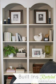 there are many pictures on the shelves in this room, including bookshelves and vases