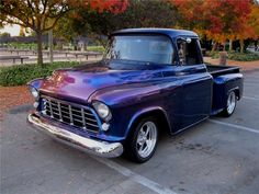 an old blue pickup truck parked in a parking lot