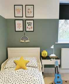 a bed room with a neatly made bed and a toy guitar on the floor next to it