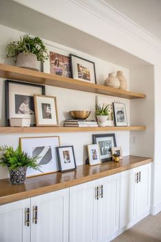 some shelves with pictures and plants on them