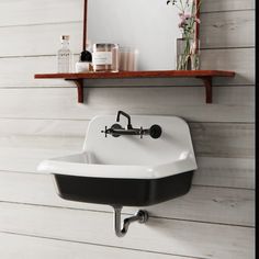 a white sink sitting under a bathroom mirror next to a shelf with bottles on it