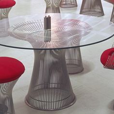 a glass table with red chairs around it