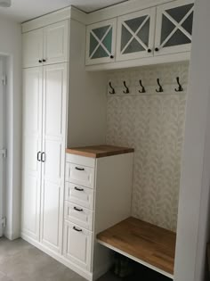 an empty room with white cabinets and drawers