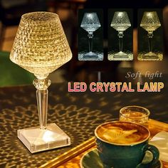 a glass lamp sitting on top of a table next to a cup of coffee