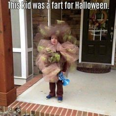 a child dressed up as a scarecrow standing in front of a house