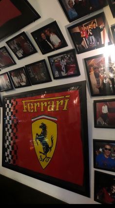 a wall covered in pictures and framed photos with ferrari logo on the front, along with other memorabilia