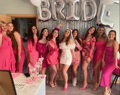 a group of women standing next to each other in front of a sign that says bride