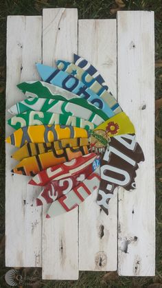 a bunch of different colored stickers on top of a white wooden planked wall