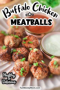 some meatballs are sitting on a plate with dipping sauce