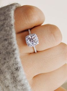 a woman's engagement ring with a heart shaped diamond in the center on her finger