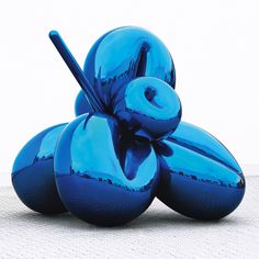 a blue sculpture sitting in front of a white wall