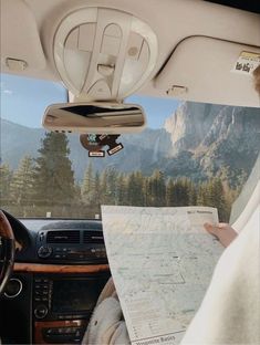 a man sitting in the driver's seat of a car looking at a map