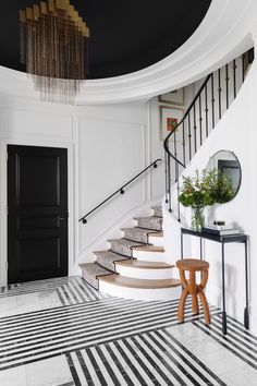 there is a black and white striped rug on the floor in front of the stairs