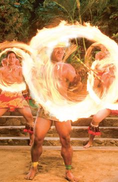 the men are doing tricks with their fire hula hoops in front of them