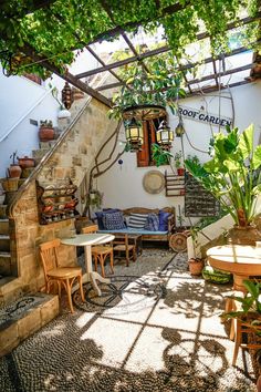 an outdoor seating area with tables and chairs under a pergolated trellis covered roof