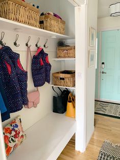 an entryway with baskets and purses hanging on the wall