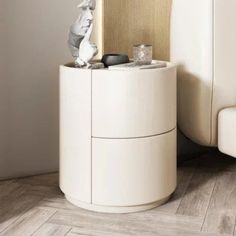 a white cabinet sitting next to a bed on top of a hard wood floored floor