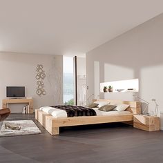 a modern bedroom with white walls and wood furniture