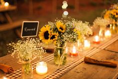 sunflowers and baby's breath are arranged in mason jars on a table