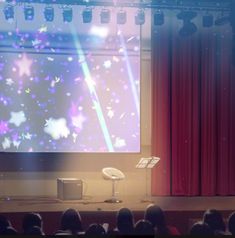 a large screen is projected on the wall in front of an audience at a conference