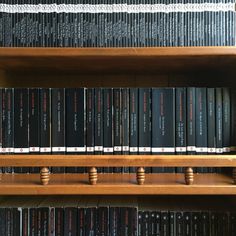 the books are lined up on the wooden shelves