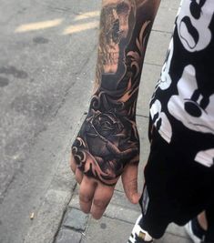 a man with a tattoo on his arm holding onto another person's hand while they both hold hands together