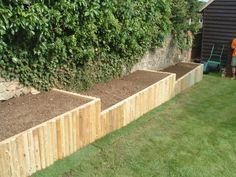 a wooden garden bed in the middle of some grass