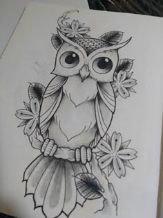 an owl sitting on top of a piece of paper with flowers around its neck and eyes