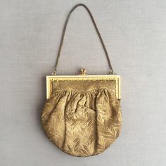 This is a mint example of an edwardian opera purse / hand bag. Fashioned out of a stiff gold brocade, Lined in an ivory cotton Attached to a gold coloured metal fame that clicks closed , held by a fine gold coloured chain. Inside is one patch pocket , which holds the original mirror.  A tiny little decorative bag big enough for your lipstick and handkerchief. Please buy this dazzling bag and take it to the opera. Supplied in a gift box Formal Yellow Gold Bags With Detachable Handle, Formal Compact Bag With Gold-tone Hardware, Compact Evening Bags With Gold-tone Hardware, Compact Formal Bag With Gold-tone Hardware, Compact Formal Bags With Gold-tone Hardware, Classic Gold Pouch Bag, Classic Gold Pouch Shoulder Bag, Vintage Gold Shoulder Bag For Party, Classic Gold Shoulder Bag For Evening