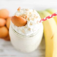 a glass jar filled with whipped cream next to bananas