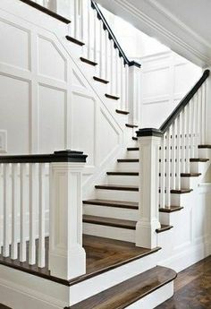 a white staircase with wooden handrails and wood flooring