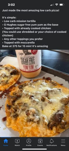 two pizzas sitting on top of a pan next to a cup of coffee and sauce