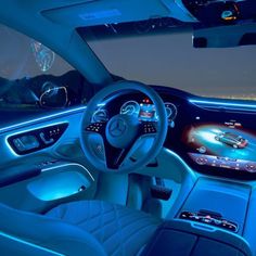 the interior of a modern car with blue lighting and dashboard lights, including an illuminated steering wheel